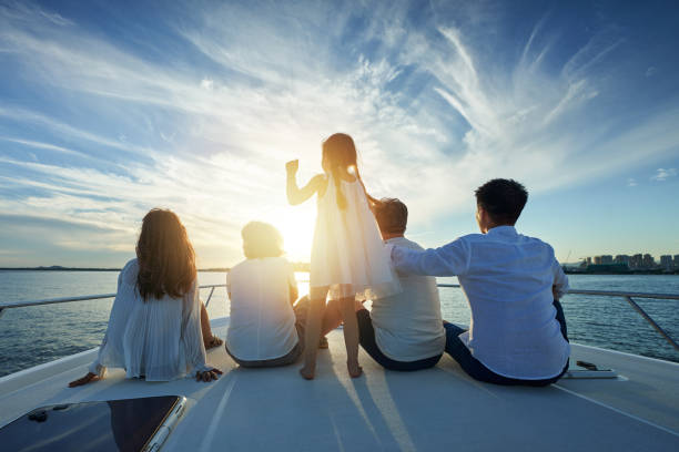 Happy family aboard a yacht out to sea - fotografia de stock