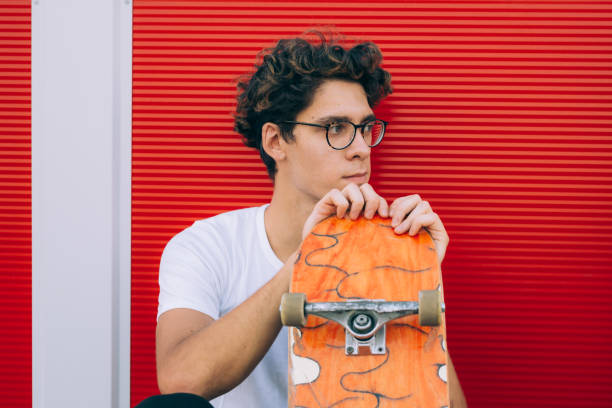 istock young man posing with his skateboard 1363735071