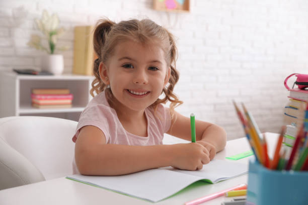 istock Cute little girl doing homework at table 1363735823
