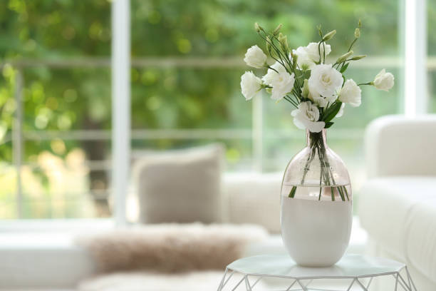 istock Vase with fresh flowers on white table in living room. Space for text 1363736068