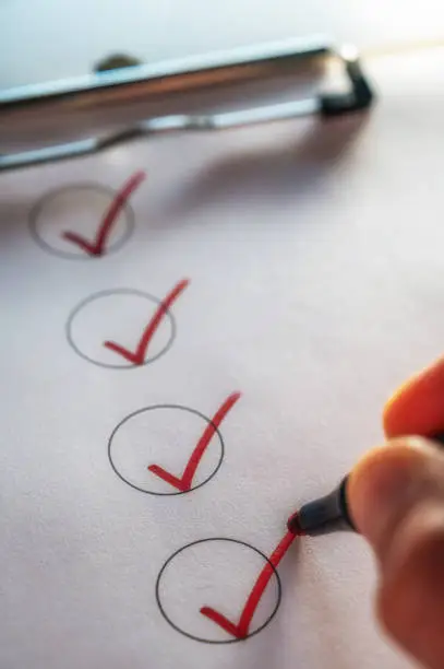 Photo of Checking off a to-do list on a clipboard with a red check mark