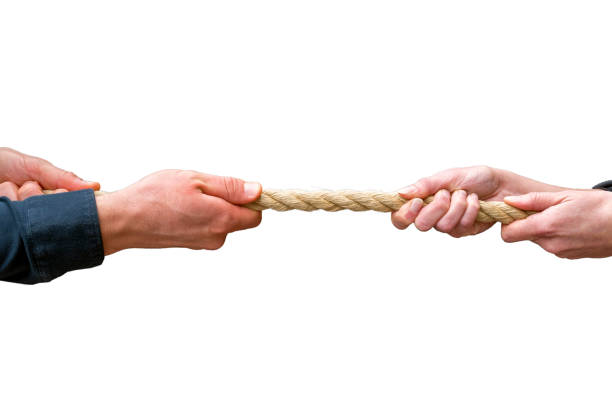 istock Male and female hands pull in opposite directions on a rope with white background 1363739112