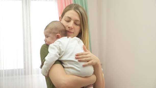 patient baby in mother's arms - colic imagens e fotografias de stock