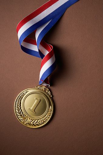 gold colored medal on brown  background