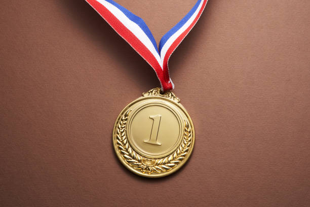 gold colored medal on brown  background gold colored medal on brown  background record breaking stock pictures, royalty-free photos & images