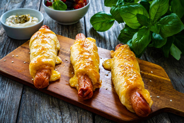 Sausage rolls - pork sausages wrapped in puff pastry on wooden table Sausage rolls - pork sausages wrapped in puff pastry sausage roll stock pictures, royalty-free photos & images