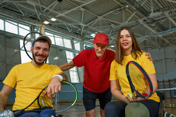 istock pair of disabled tennis players hugging each other with their master 1363743263