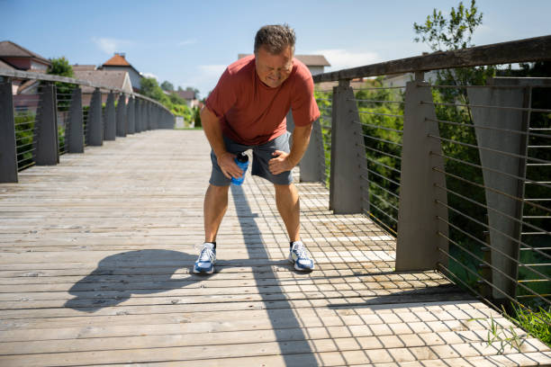 Man catching up breathe after running in public park