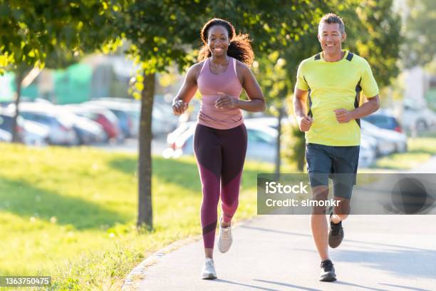 Man And Woman Running In Public Park Stock Photo - Download Image Now - Running, Healthy Lifestyle, Jogging