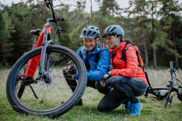 istock Active senior couple mending bicycle outdoors in forest in autumn day. 1363750526