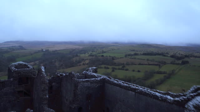 Dramatic dark and moody close proximity aerial of Carreg Cennen Castle in Wales