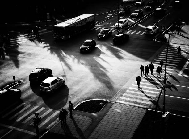 hochwinkelansicht der städtischen menschenmenge in der silhouettenkreuzung, die zur hauptverkehrszeit mit verkehr beschäftigt ist - rush hour commuter shadow focus on shadow stock-fotos und bilder