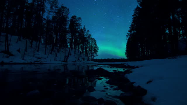 Stunning cinematic day to night motion timelapse of the Aurora over an icy stream