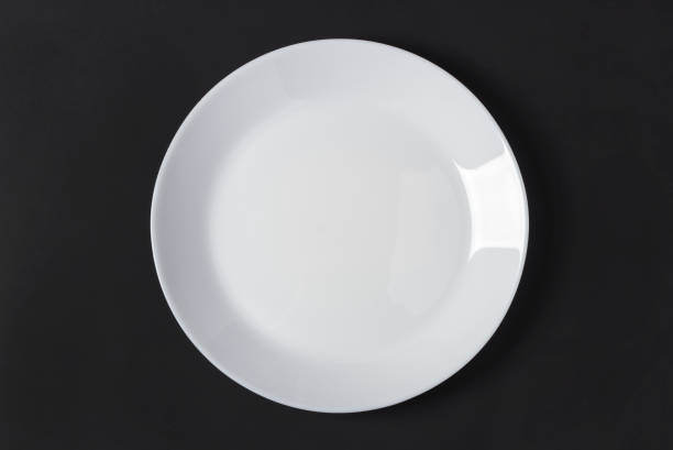istock White porcelain plate on black 1363752162