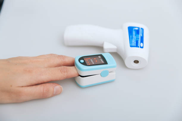 istock Pulse oximeter and thermometer gun on white background. Measuring oxygen saturation, pulse rate and oxygen levels. Infrared isometric thermometer gun to check body temperature for virus symptoms 1363752233
