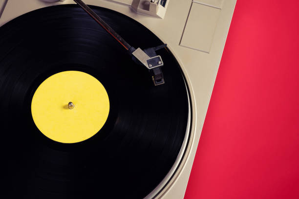 istock Vintage player record with a vinyl record on a red table close up 1363752359