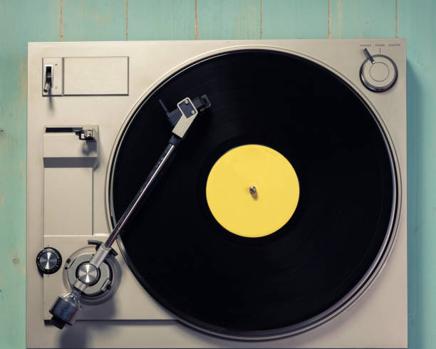 istock Vintage player record with a vinyl record on a wooden table close up 1363752669
