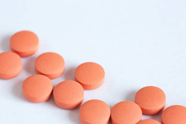 istock Orange round pills close-up, medicines on a white background, top view, copy space 1363754348