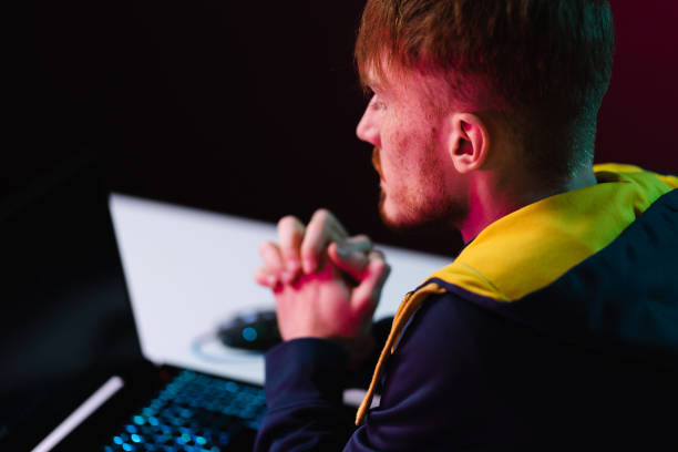 istock Gamer playing video games with headphones on neon light background 1363756582