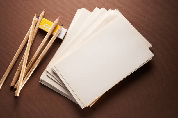 sketch pad with color pencils and eraser on brown background