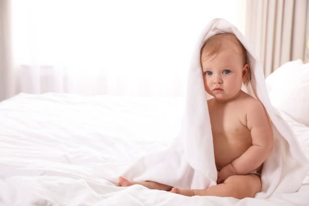 istock Cute little baby with soft towel on bed after bath. Space for text 1363761713