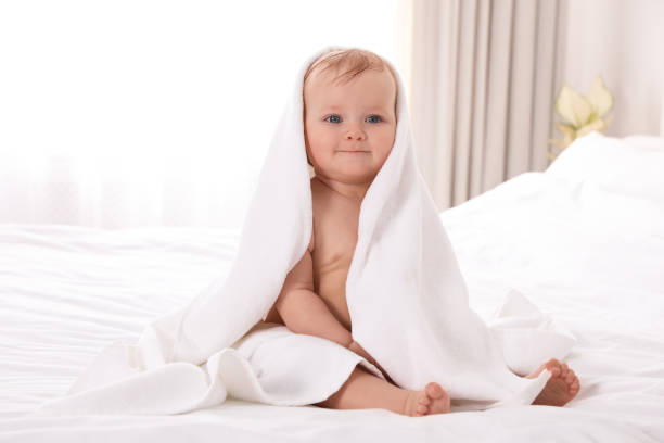istock Cute little baby with soft towel on bed after bath 1363761915