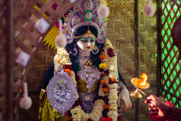 rituels du festival saraswati puja exécutés par un prêtre. idole de la déesse hindoue saraswati en arrière-plan. - hinduism goddess ceremony india photos et images de collection