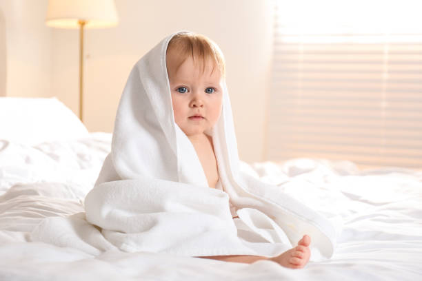 istock Cute little baby with soft towel on bed after bath 1363762087