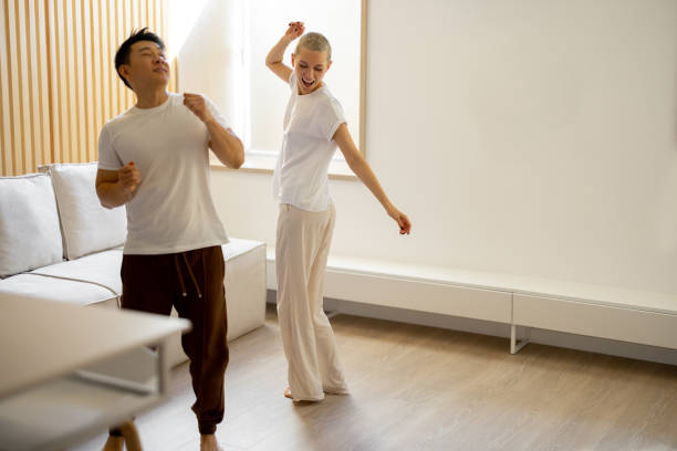 istock Multiracial couple dancing while resting at home 1363762769