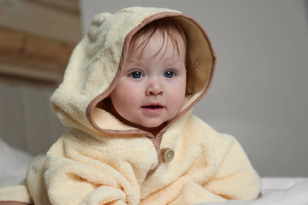 istock Cute little baby in yellow hooded towel on bed after bath 1363763243