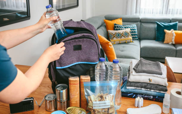 istock Woman putting a water bottle to prepare emergency backpack 1363765757