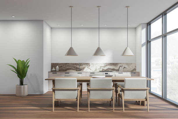 istock White kitchen interior with table and seats, wooden floor and window 1363765769