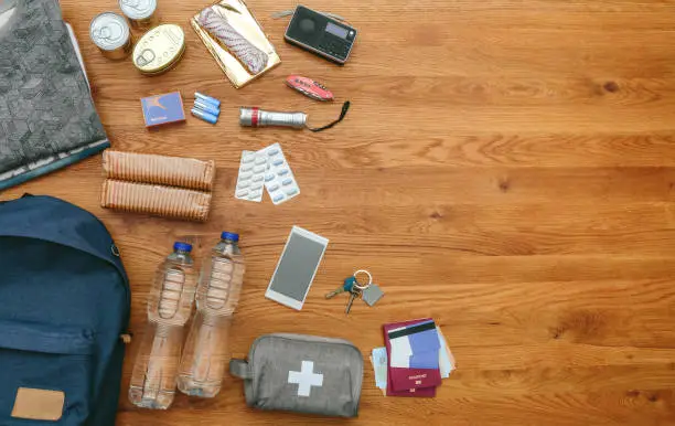 Top view of emergency backpack preparations with necessities