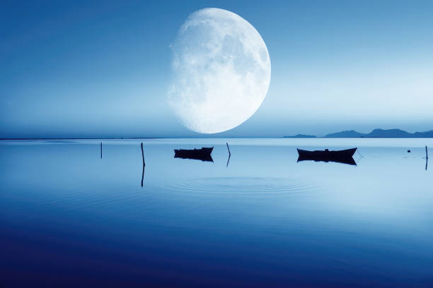 Magic blue night sky landscape with clouds and fullmoon and stars closeup.