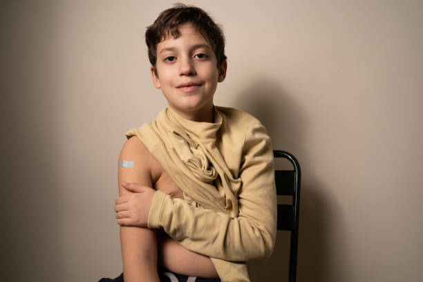 istock Kid showing vaccinated arm with adhesive bandage - Children vaccination concept 1363765844