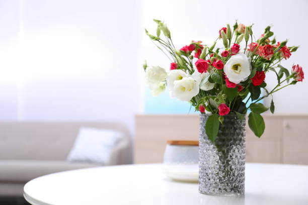 istock Vase with beautiful flowers on white table in room, space for text 1363765877