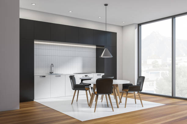 istock Black and white kitchen interior with table and chairs, wooden floor and window 1363766326