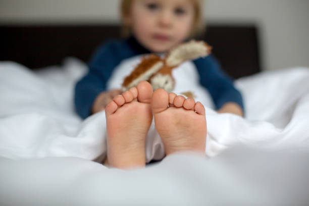 istock Cute child, lying in bed, playing with little stuff toy 1363766976