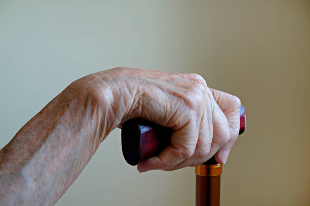 先輩女性の手を手にして、手を閉じて。 - human hand aging process senior adult cane ストックフォトと画像