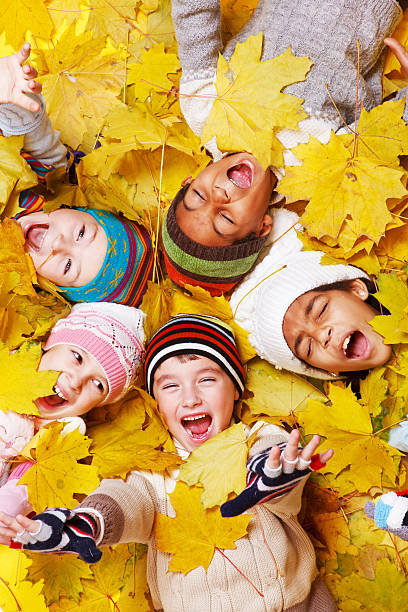Excited children in yellow leaves