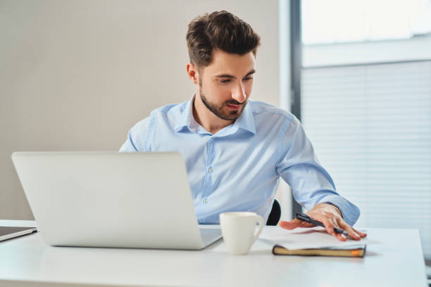 istock Busy businessman working on laptop looking on document 1363769170