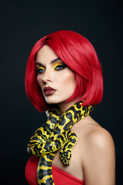 Beautiful woman with red hair and a yellow python snake around her neck. Professional Bright Beauty Eye Makeup Yellow, Red Burgundy Lipstick