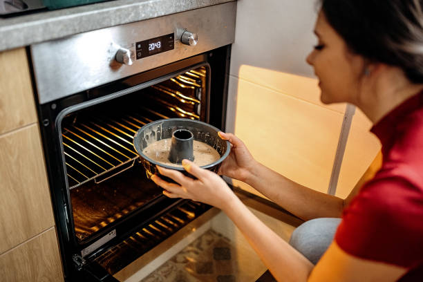 mulher colocando bolo no forno - bolo ingles - fotografias e filmes do acervo