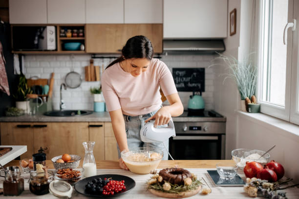 istock Young beautiful woman making a cake mixture 1363770026