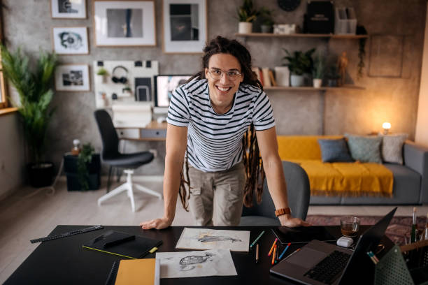 Young handsome hipster man posing in his home office Young handsome hipster man posing in his home office young graphic designer stock pictures, royalty-free photos & images