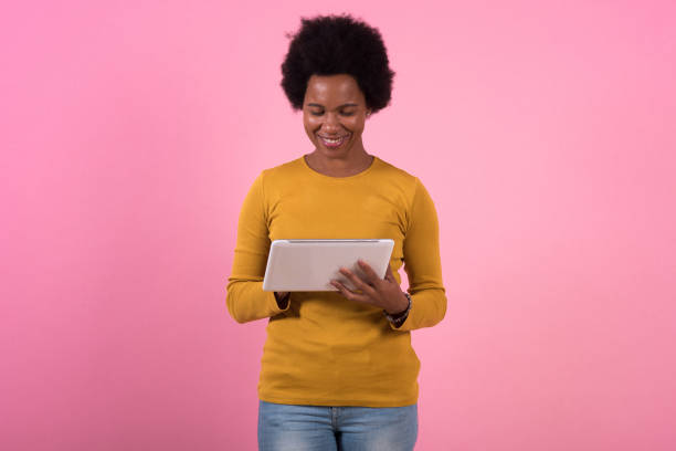 istock Studio portrait of a happy African woman using digital tablet 1363771181