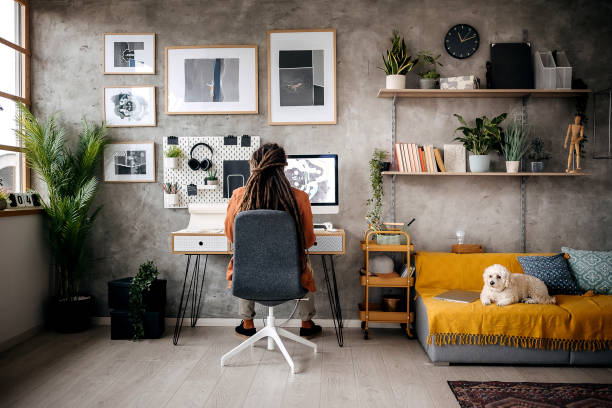 Young graphic designer working from his home office while his dog is laying near him Young graphic designer working from his home office while his dog is laying near him young graphic designer stock pictures, royalty-free photos & images