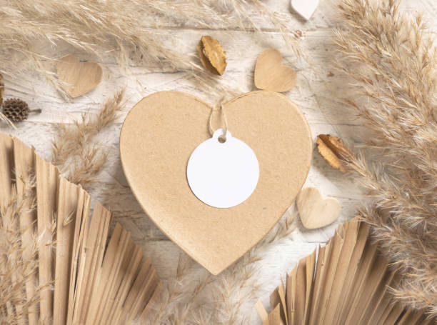 istock Heart shaped Valentines present with round blank gift tag, pampas grass and hearts, boho Mockup 1363773189