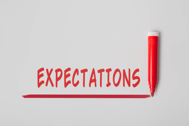 istock The word 'Expectations', written with red marker over red line, isolated on gray background 1363773792