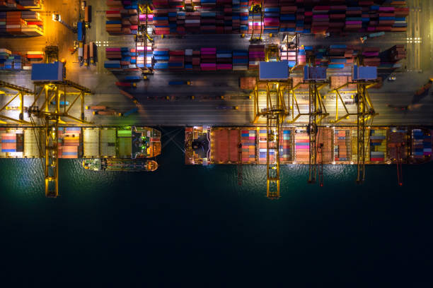 istock Container ship loading and unloading in deep sea port, Aerial view at night 1363774771